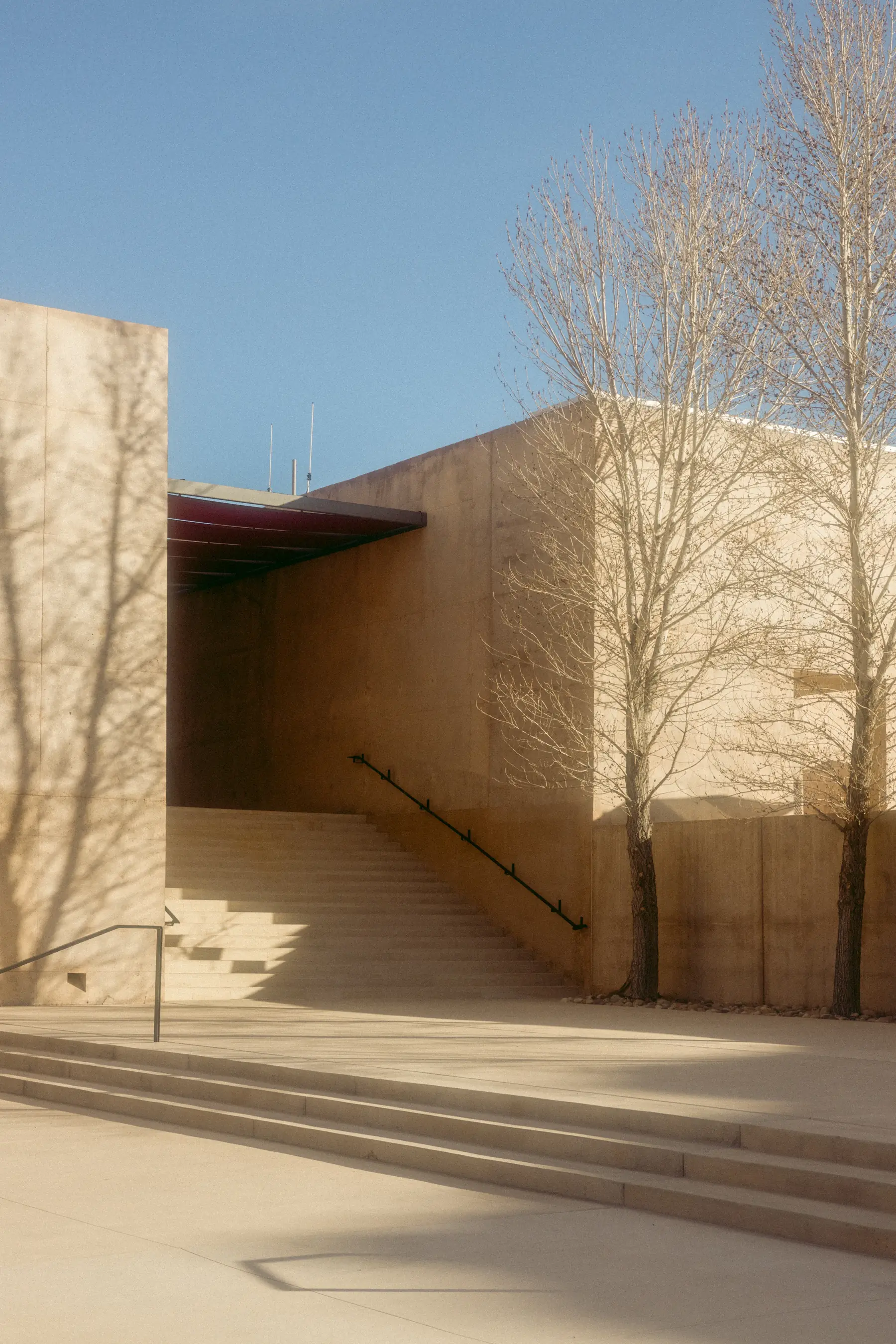 Sunlit stone architecture at Amangiri with tree shadows and broad stairs